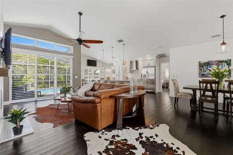 a kitchen with stainless steel appliances kitchen island granite countertop a sink and a white wooden cabinets