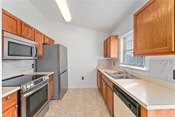 a kitchen with stainless steel appliances granite countertop a sink stove and refrigerator