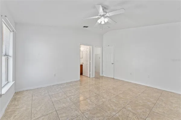 a view of an empty room with a ceiling fan