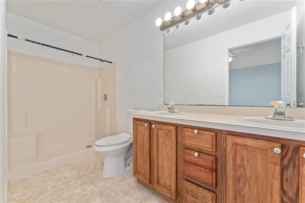 a bathroom with a double vanity sink and a toilet