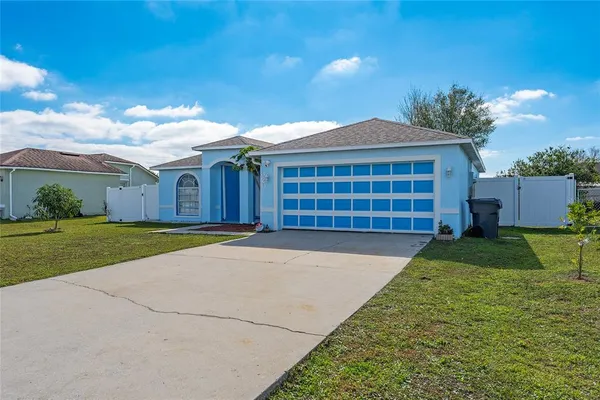 a front view of a house with a garden and plants