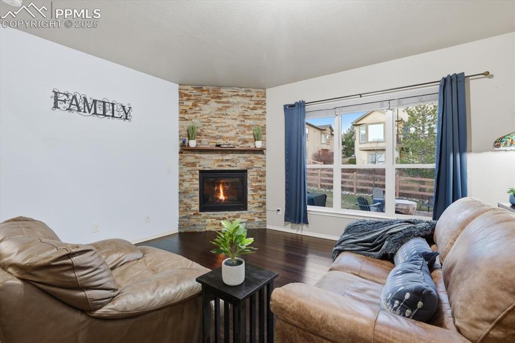 2374 Cinnabar Road Colorado Springs, CO 80921 - Photo 16 of 47 The living room is kept cozy with a corner gas fireplace with a stone surroud.