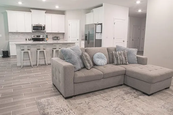 a living room with furniture and a view of kitchen