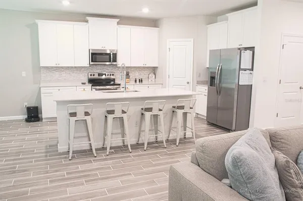 a kitchen with stainless steel appliances kitchen island granite countertop a refrigerator and microwave