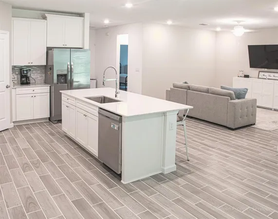 a kitchen with a sink cabinets and wooden floor