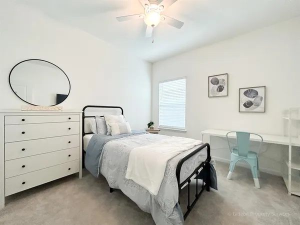 a bedroom with a bed a chandelier and a dresser