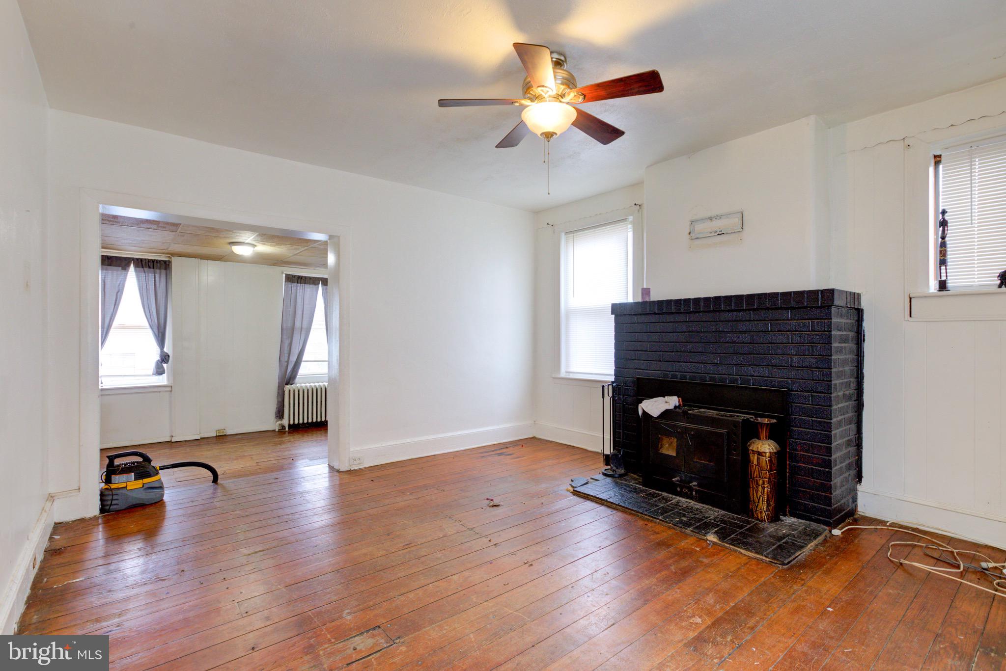 15 7th Street Brookhaven, PA 19015 - Photo 5 of 33 a view of an empty room with wooden floor a fireplace and a window