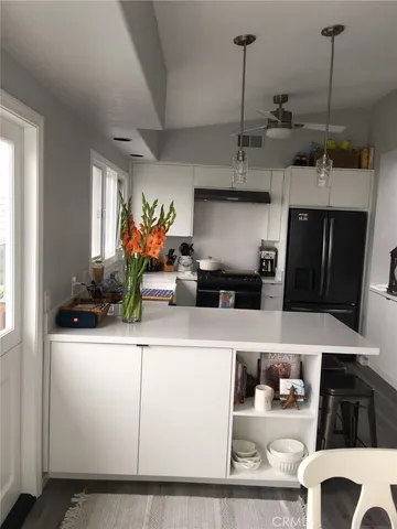 a kitchen with stainless steel appliances granite countertop a sink and white cabinets