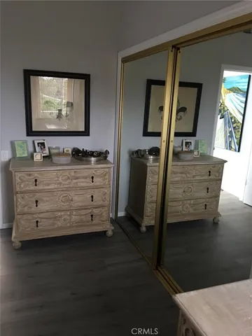 a view of room with mirror and wooden floor