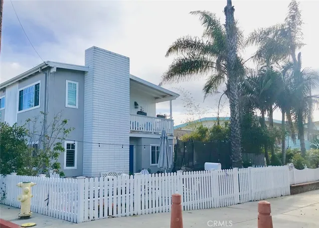 a white house that has tree in front of it