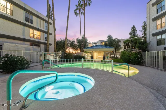 a view of a swimming pool with a yard and palm trees