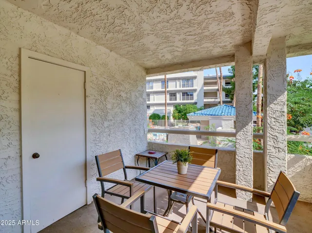 a view of a balcony with table and chairs