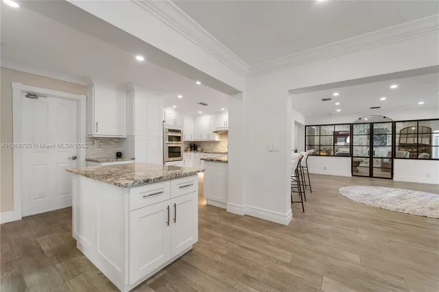 a kitchen with a sink stove and wooden floor