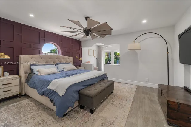 a bedroom with a bed mirror and window