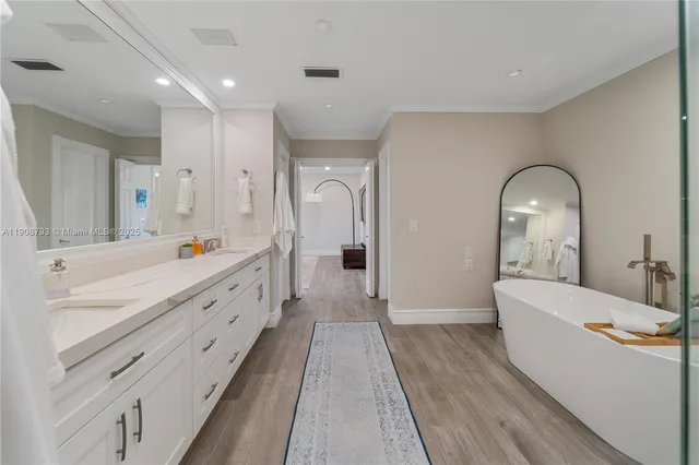 a spacious bathroom with a double vanity sink a mirror and a bathtub