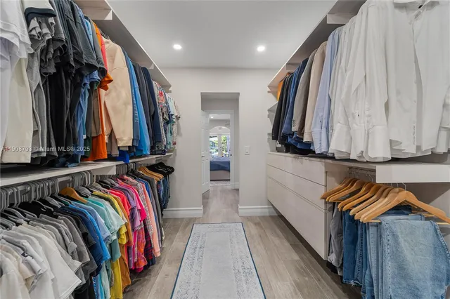 a view of walk in closet with clothes and shoes