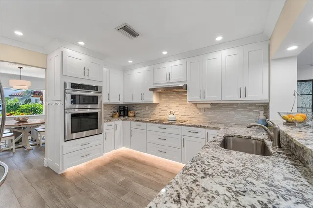a kitchen with a sink a microwave a stove and refrigerator
