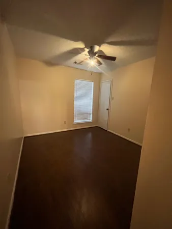 a view of a small space with wooden floor and a ceiling fan