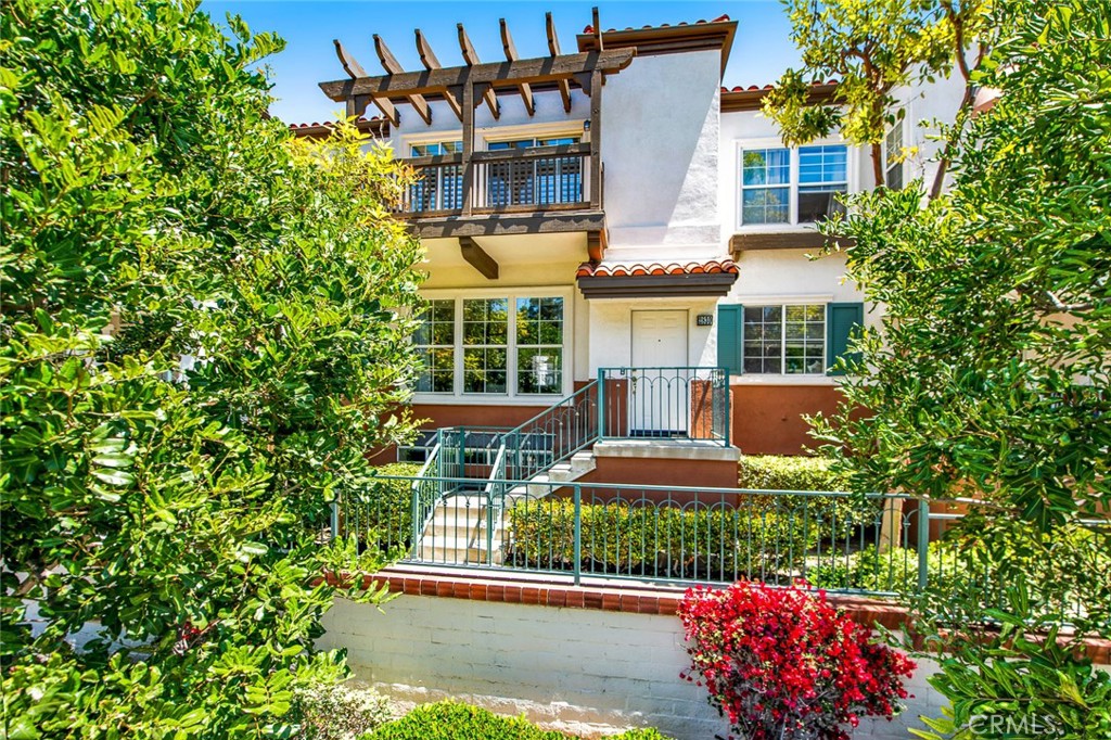 a front view of a house with a yard and fountain in middle of the house