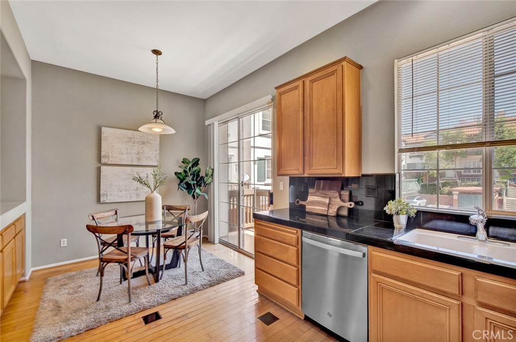 2830 Ballesteros Lane Tustin, CA 92782 - Photo 6 of 28 a kitchen with granite countertop a table chairs sink and cabinets