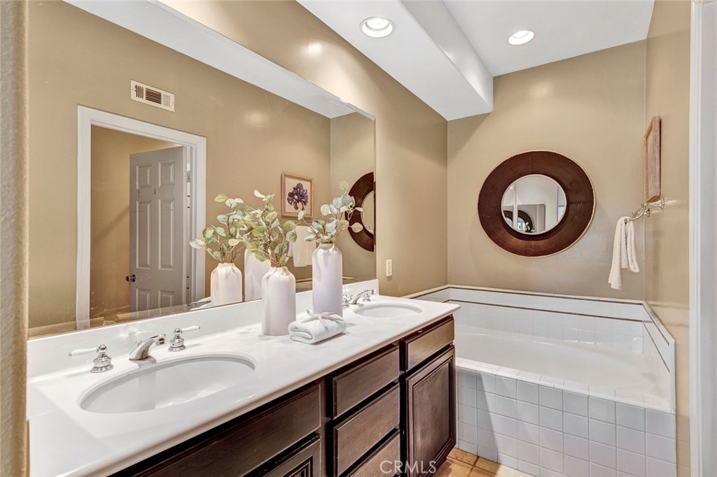 2830 Ballesteros Lane Tustin, CA 92782 - Photo 10 of 28 a bathroom with a granite countertop double vanity and a mirror