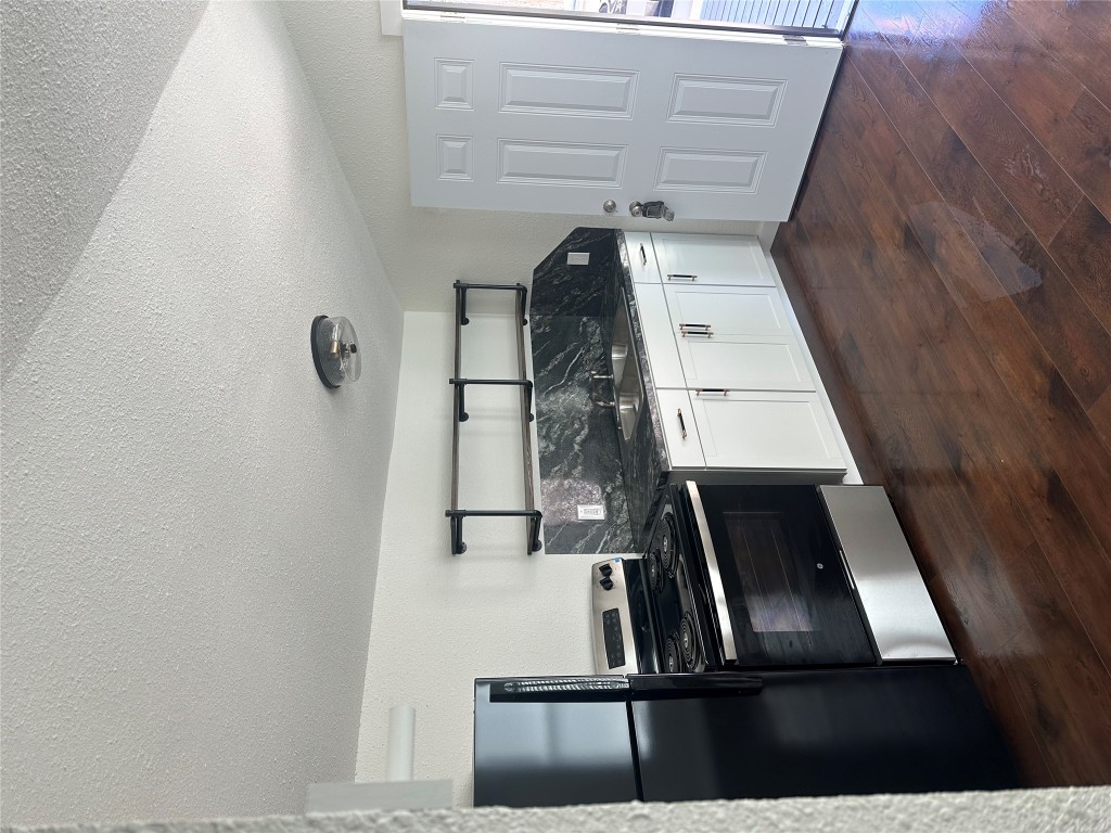 3019 East 12th Street Austin, TX 78702 - Photo 3 of 12 a kitchen with granite countertop white cabinets and stainless steel appliances