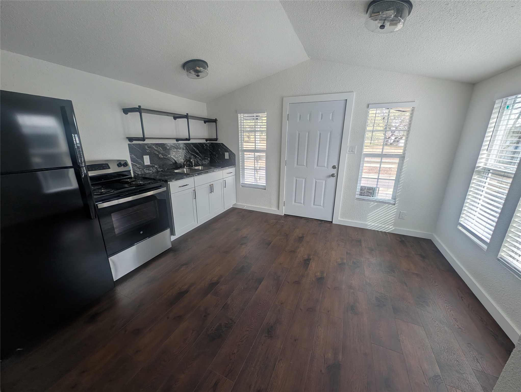 3019 East 12th Street Austin, TX 78702 - Photo 4 of 12 a kitchen with stainless steel appliances granite countertop a stove and a refrigerator