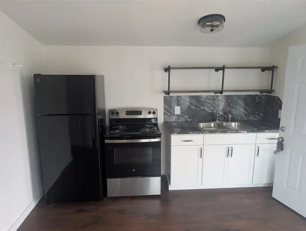 a kitchen with a refrigerator and white cabinets
