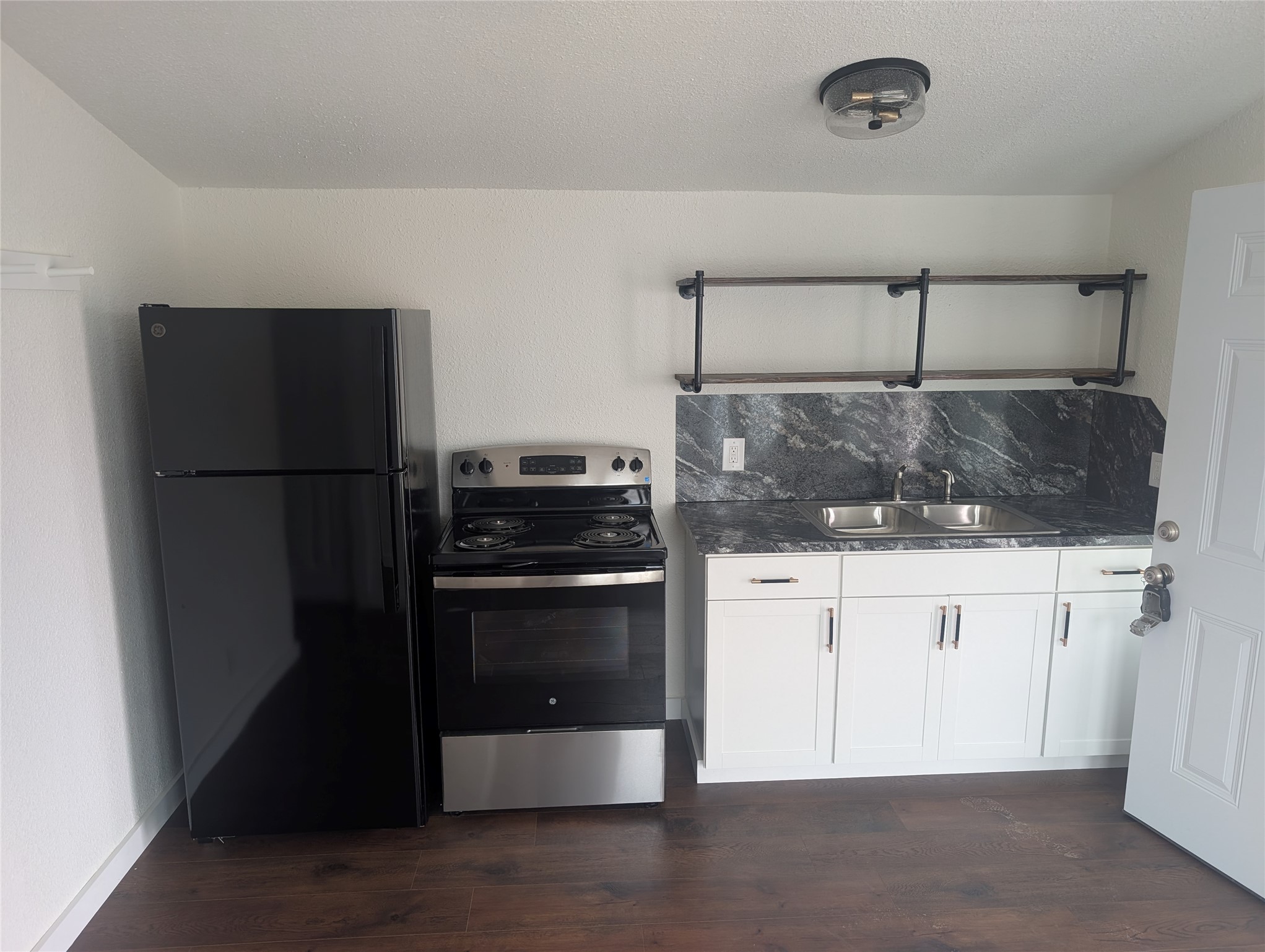 3019 East 12th Street Austin, TX 78702 - Photo 5 of 12 a kitchen with a refrigerator and white cabinets
