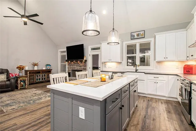 a kitchen that has a lot of cabinets in it and wooden floor