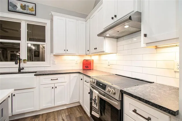 a kitchen with stainless steel appliances granite countertop a sink and cabinets