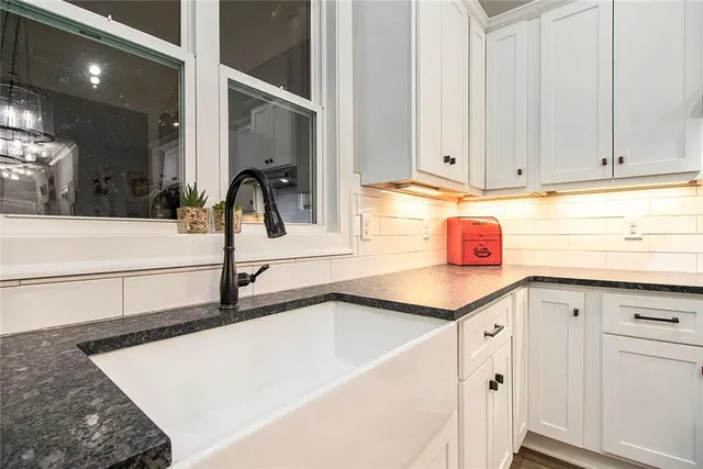 a kitchen with granite countertop a sink and cabinets