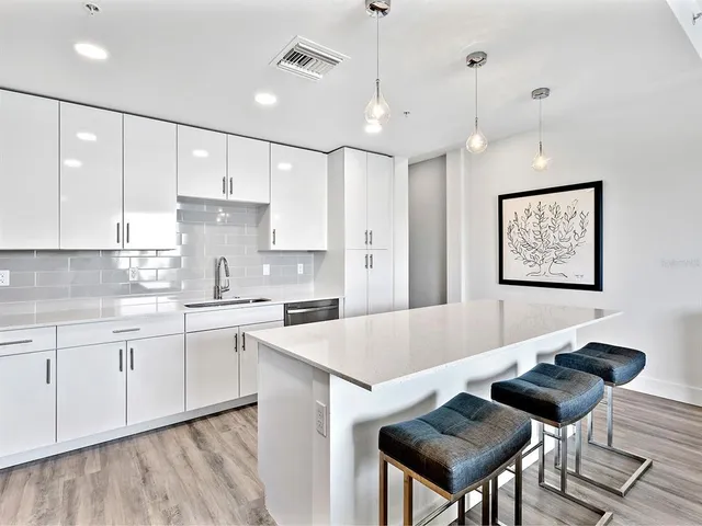 a large kitchen with cabinets table and chairs