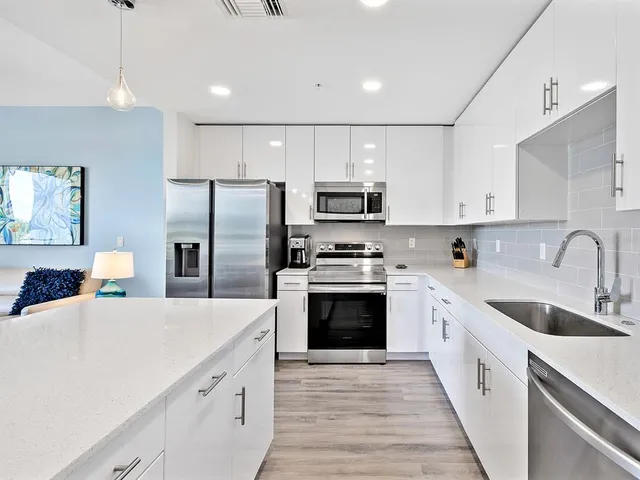 a kitchen with kitchen island a sink stainless steel appliances and cabinets