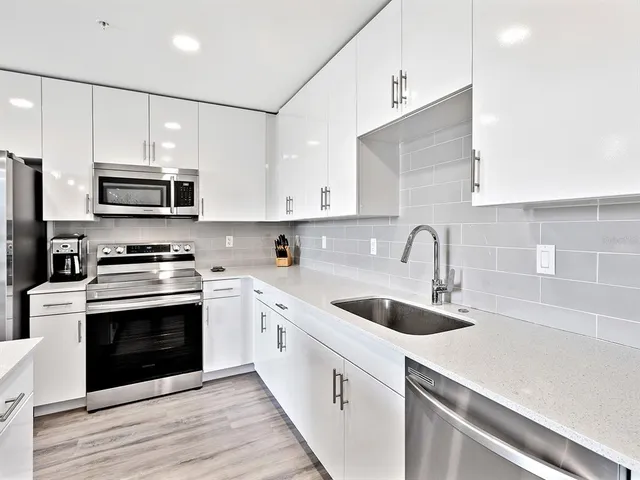 a kitchen with stainless steel appliances granite countertop a sink stove a microwave and cabinets