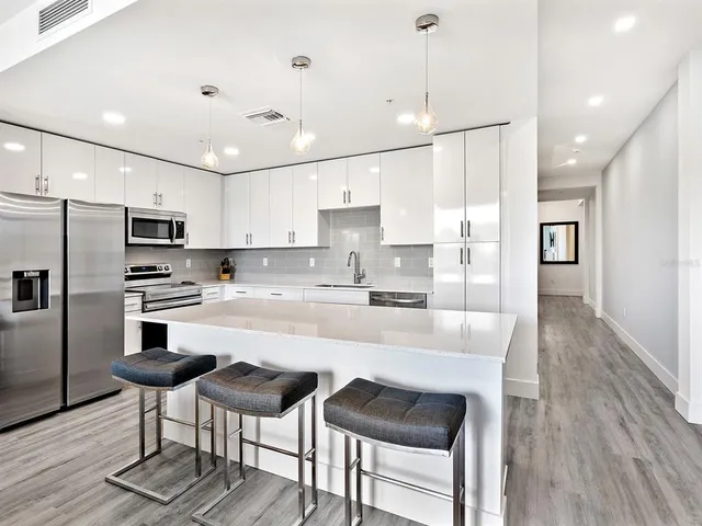 a large kitchen with kitchen island a dining table and chairs