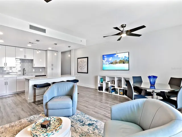 a living room with furniture a rug and kitchen view