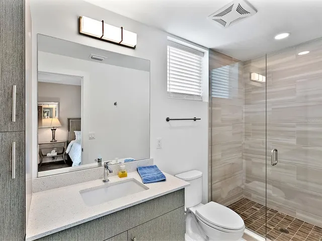 a bathroom with a sink toilet vanity and shower