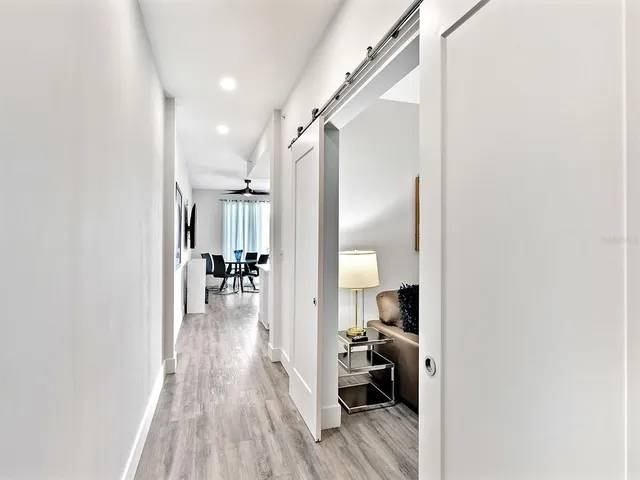 a hallway with a couch and a dining table next to a window