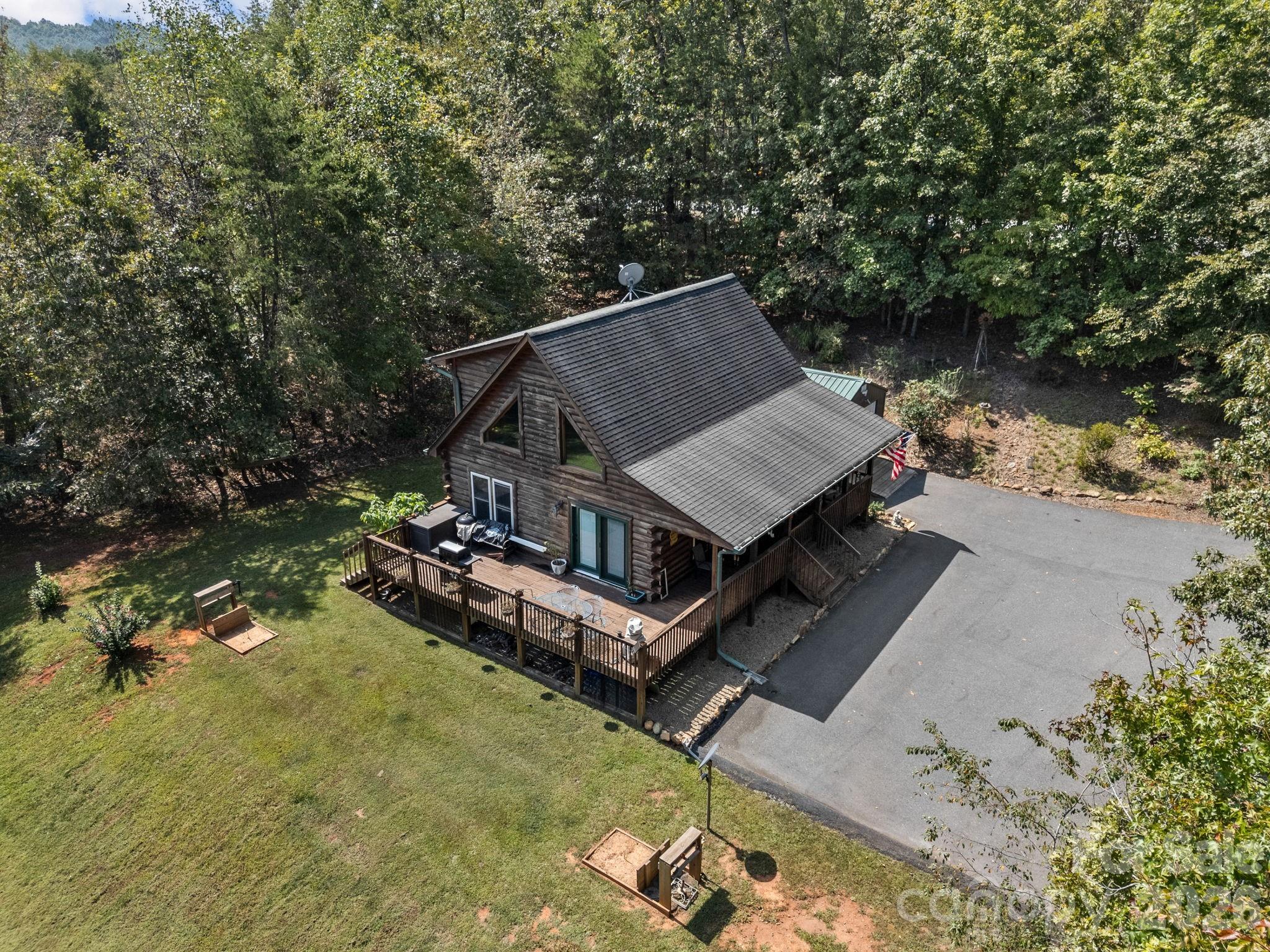 an aerial view of a house with swimming pool and large trees