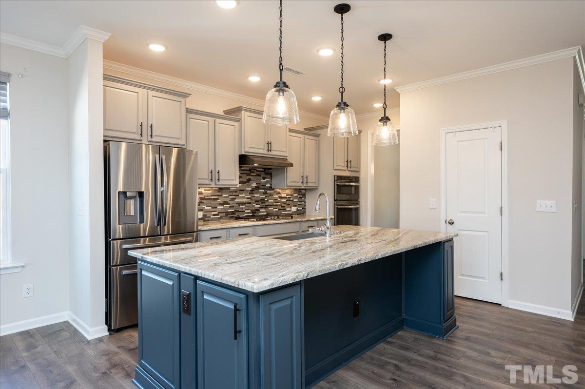 434 Streamliner Boulevard Clayton, NC 27520 - Photo 13 of 27 a kitchen with kitchen island a counter space a sink appliances and cabinets