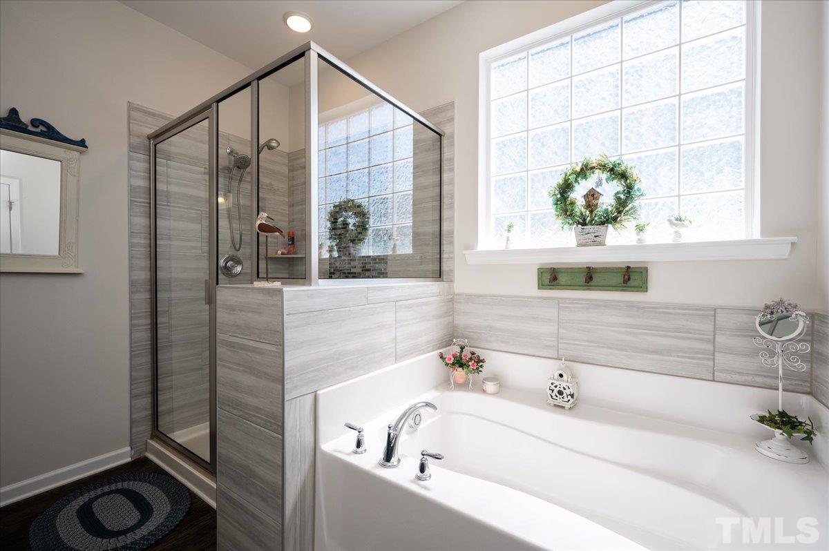 434 Streamliner Boulevard Clayton, NC 27520 - Photo 19 of 27 a bathroom with a tub sink and mirror