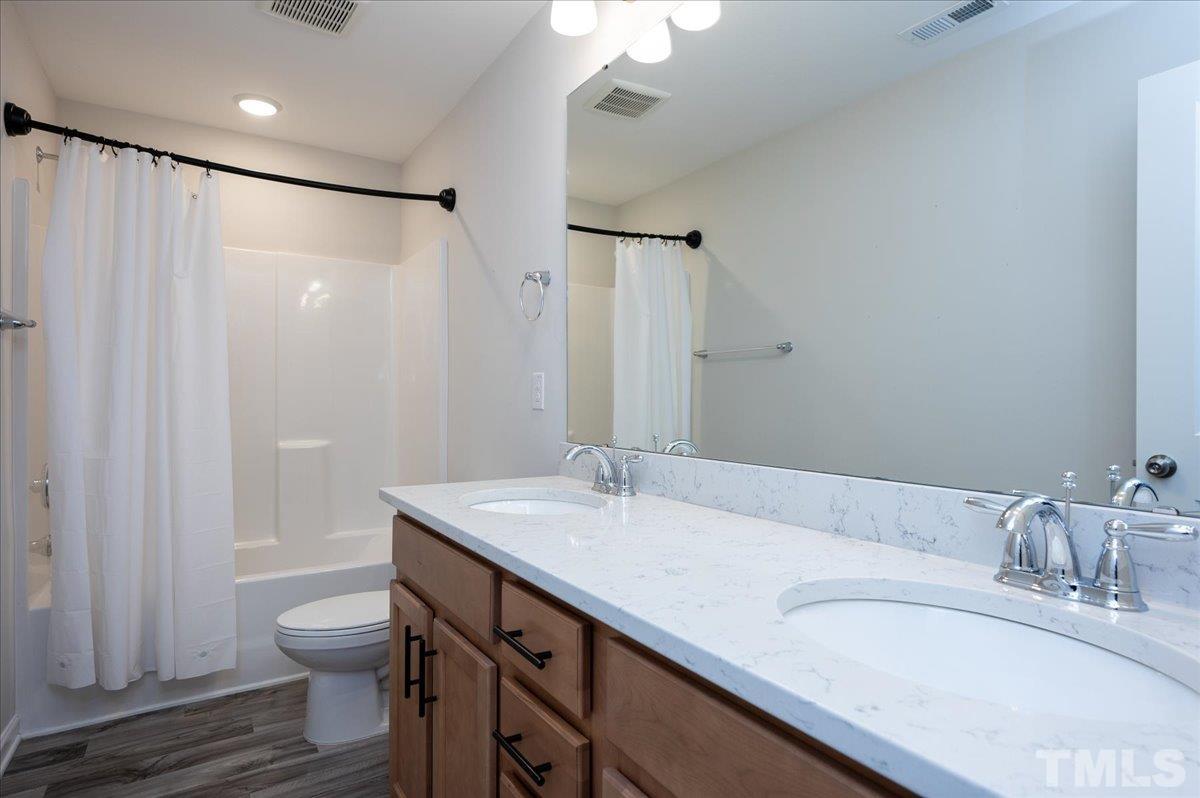 434 Streamliner Boulevard Clayton, NC 27520 - Photo 24 of 27 a bathroom with a granite countertop sink toilet and shower
