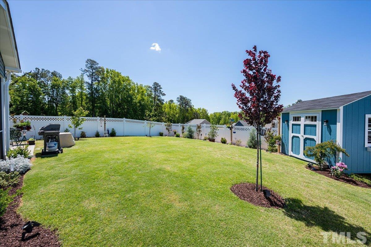 434 Streamliner Boulevard Clayton, NC 27520 - Photo 6 of 27 a view of a backyard with table and chairs potted plants and palm tree