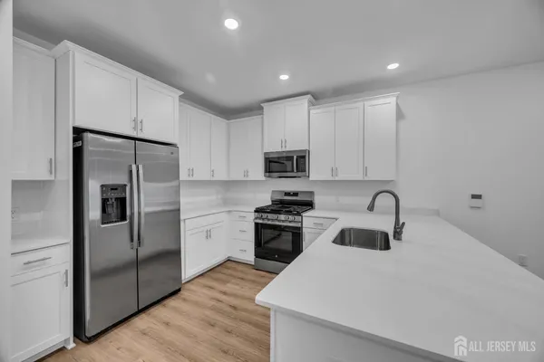 a kitchen with kitchen island a sink stainless steel appliances and cabinets