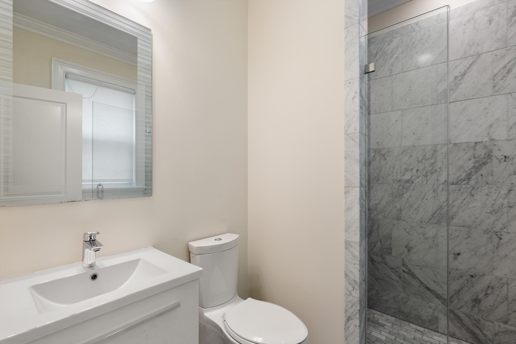 197 Rawson Road, Unit 1 Brookline, MA 02445 - Photo 23 of 27 a bathroom with a sink a toilet and a mirror
