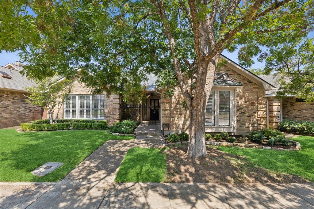 14320 Regency Place Dallas, TX 75254 - Photo 1 of 1 a view of a brick house next to a yard with big trees