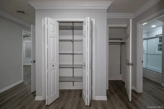 a view of walk in closet with wooden floor