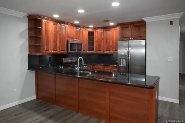 a kitchen with stainless steel appliances granite countertop a sink a refrigerator and a granite counter tops