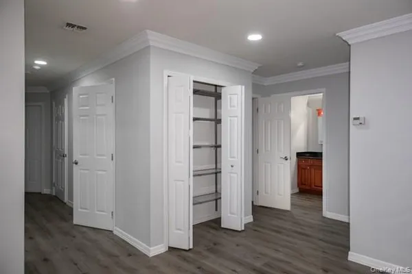 an empty room with wooden floor & closet and bathroom